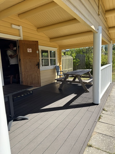 Overdækket terrasse med bord-bænkesæt